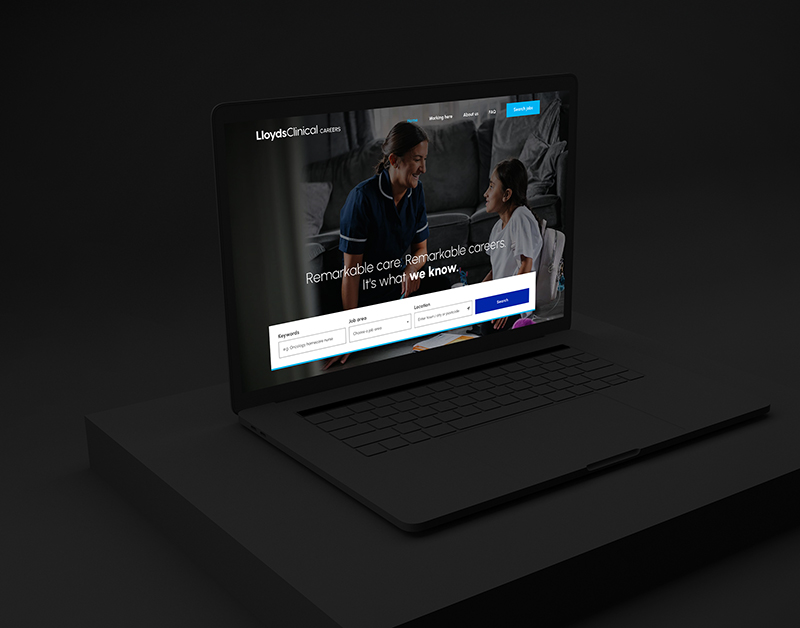 A laptop on a dark surface displays a website for LloydsClinical careers, highlighting how they are transforming recruitment through powerful employer branding solutions. The screen shows a smiling adult and child, with text about remarkable care and careers. Search bars for keywords, location, and distance are visible.